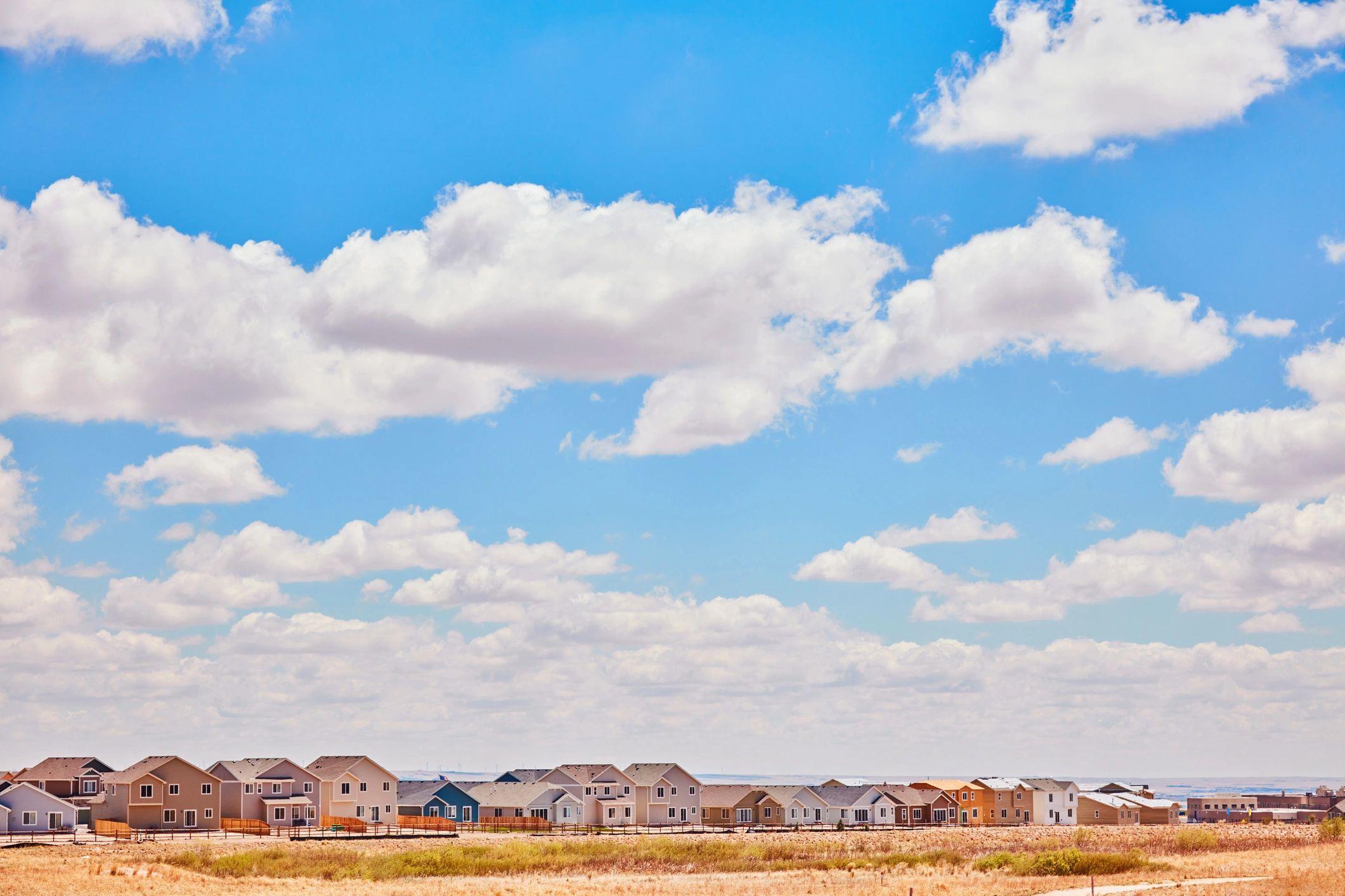 Newly constructed residential homes in Mid Western USA under bright blue sky with clouds